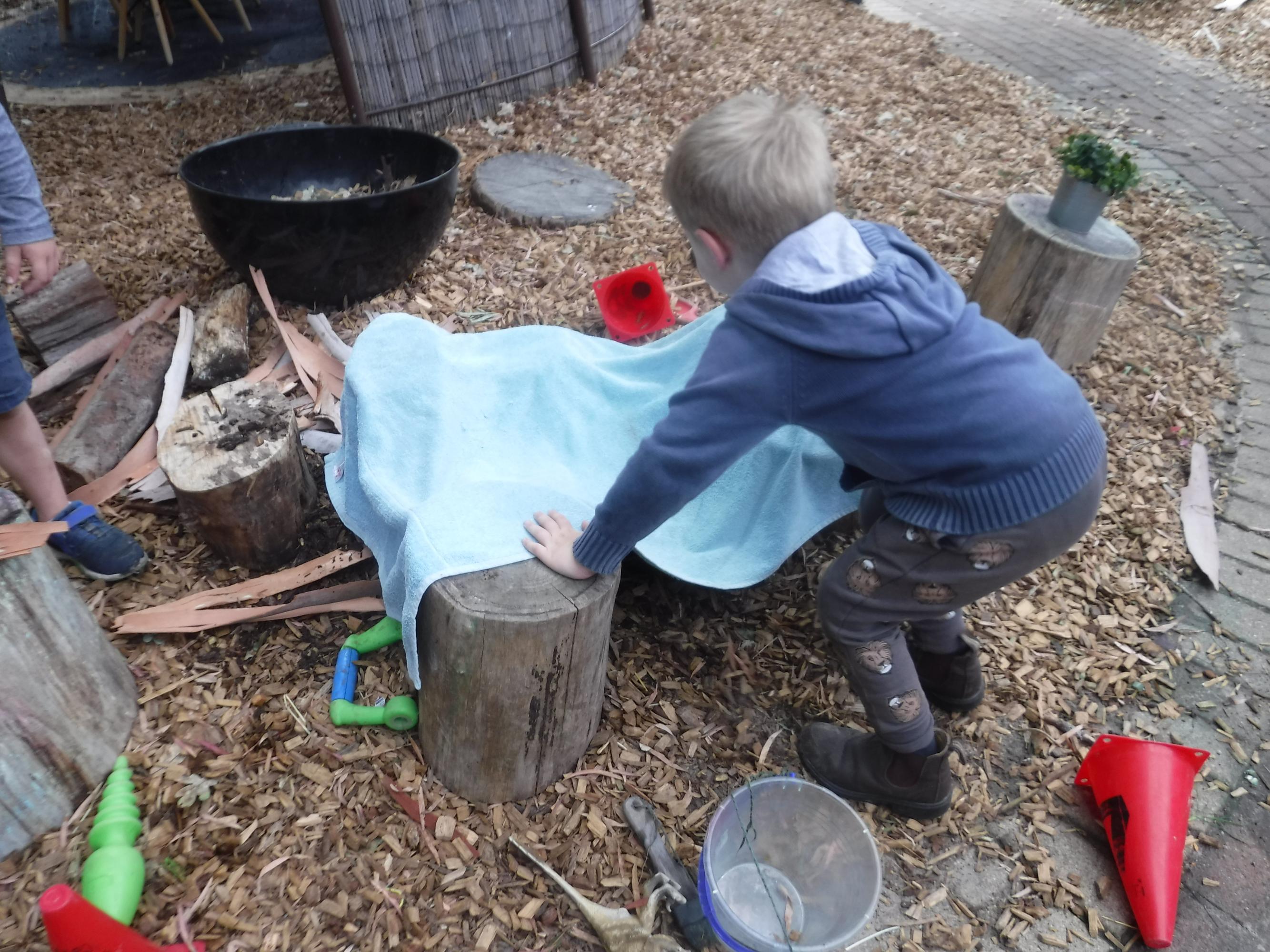 loose parts play, children playing with wood pieces from a tree