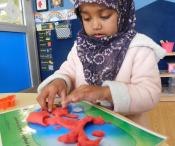 Young child making shapes with play-dough inside