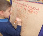 Child writing points on a large score board